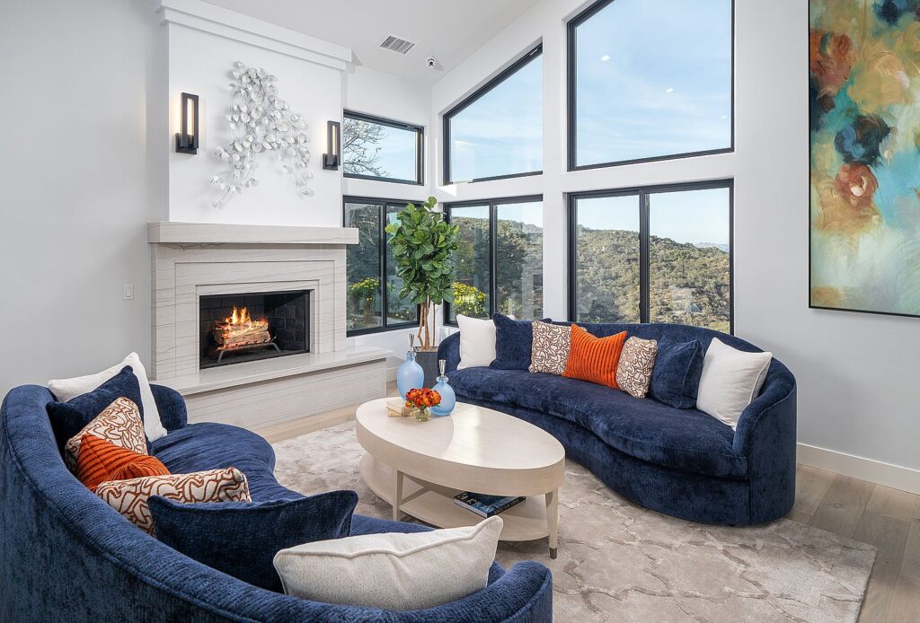 A living room with a fireplace and deep blue couches.