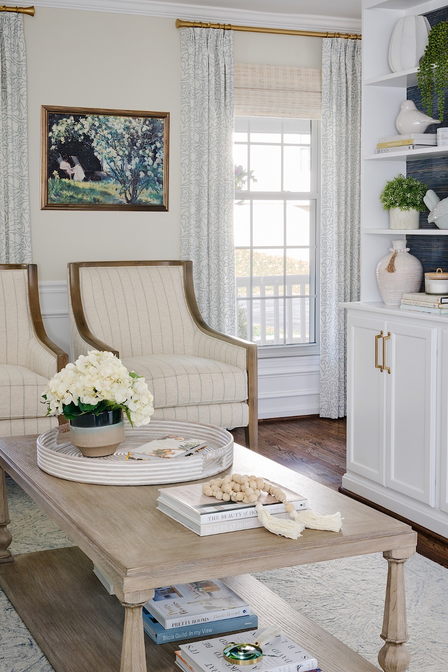 A living room with white chairs and a coffee table. Enhance your home with touches of nature with Biophilic design.